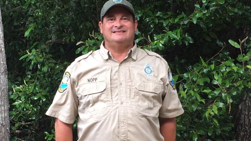 Park Ranger Garin Nopp standing in front of greenery